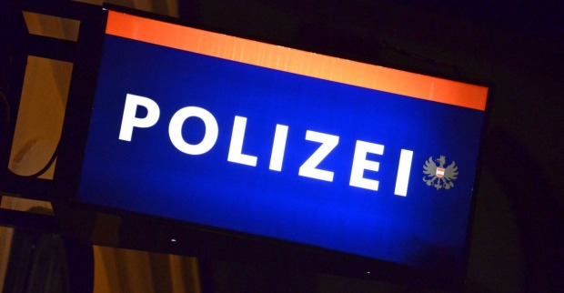 Schild einer Polizeiwache in der Nacht.
