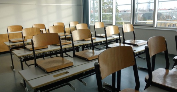 verlassenes Klassenzimmer mit Stühlen, die auf den Tisch gestellt sind