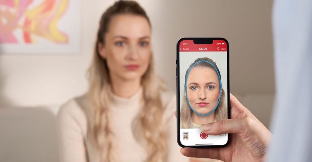 Junge Frau wird mit Handy fotografiert