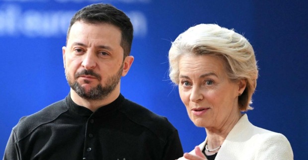 Der ukrainische Präsident Wolodymyr Selenskyj steht neben EU-Kommissionspräsidentin Ursula von der Leyen vor blauem Hintergrund. Beide blicken ernst, von der Leyen spricht mit leicht erhobener Handgeste.