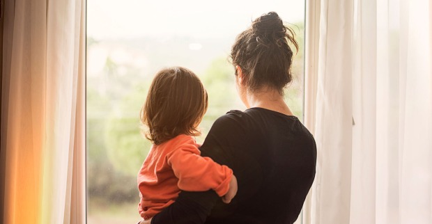 Frau mit Kind am Fenster | Credit: iStock.com/Kaan Sezer