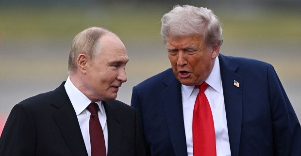 Donald Trump und Wladimir Putin gehen nebeneinander und sprechen miteinander beim Treffen in Alaska. Beide wirken freundlich und im Gespräch vertieft.