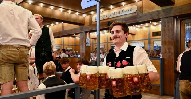 Kellner auf dem Münchner Oktoberfest trägt Maßkrüge