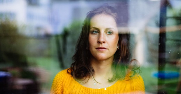 Frau schaut nachdenklich aus dem Fenster | Credit: iStock.com/Matthias Lindner