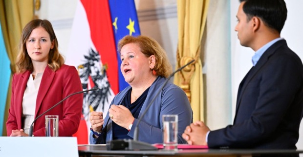 Integrationsministerin Claudia Plakolm (ÖVP), Sozialministerin Korinna Schumann (SPÖ) und NEOS-Klubobmann Yannick Shetty präsentierten im Bundeskanzleramt die Eckpunkte der „Sozialhilfe NEU“. Im Hintergrund die österreichische und die EU-Flagge.