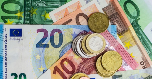 Verschiedenste Euro-Noten und Münzen auf einem Tisch liegend