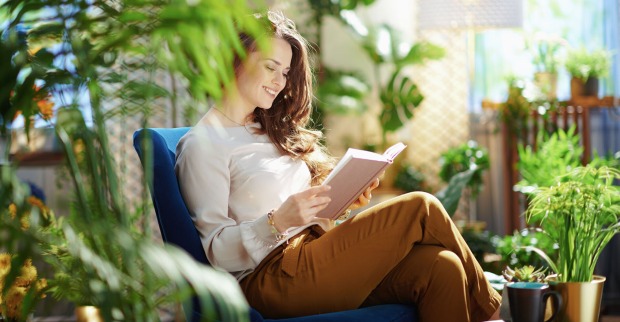 Frau sitzt in der Mitte von Pflanzen | Credit: iStock.com/CentralITAlliance