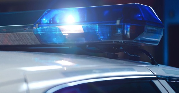 Polizeiwagen in der Nacht mit eingeschalteter Sirene auf dem Fahrzeugdach