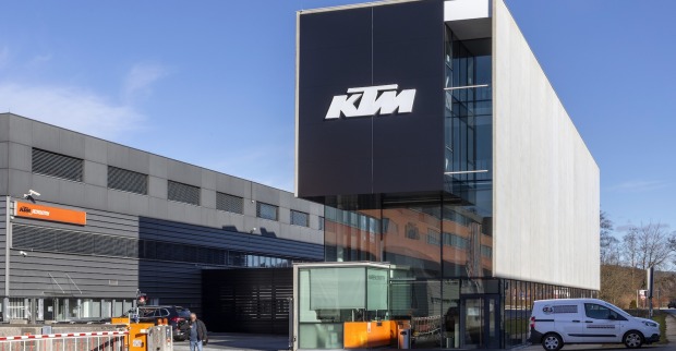 Moderne Gebäudefassade des KTM-Stammwerks in Mattighofen mit großem KTM-Logo, aufgenommen bei Sonnenschein