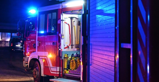 Feuerwehrwagen bei Nacht während eines Einsatzes mit eingeschalteter Sirene