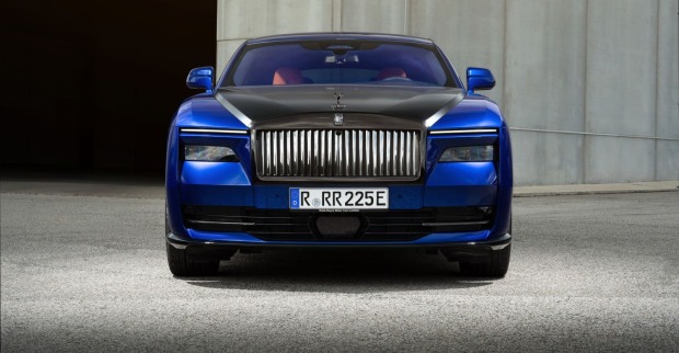 Ein Rolls-Royce  Black Badge Spectre park auf einem betonierten Platz. Der blaue Luxuswagen glänzt in der Sonne.