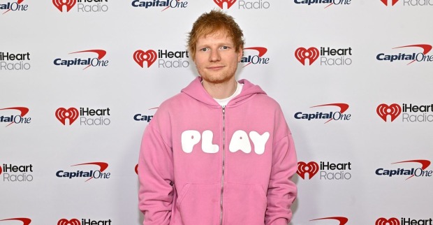 Ed Sheeran in einem rosa Pulli auf einer Veranstaltung.