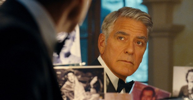 George Clooney blickt in einen Spiegel.