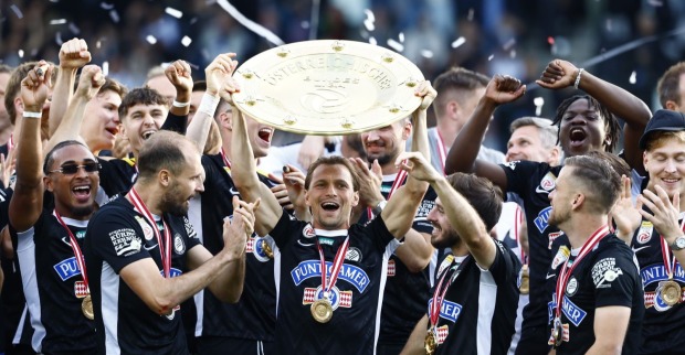 Die Mannschaft von Sk Sturm Graz feiert jubelnd und hält den Meisterteller in die Höhe.