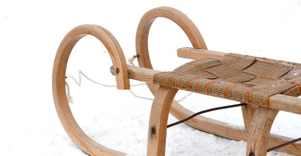 Eine Rodel aus Holz steht im Schnee