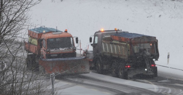 Zwei Schneepflüge räumen eine schneebedeckte Straße in Kärnten während anhaltendem Schneefall.