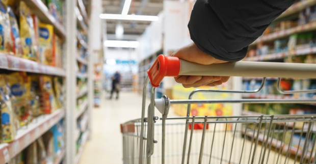 Einkaufswagen in einem Supermarktgang, Symbolbild für neue Kennzeichnungspflicht bei Shrinkflation in Österreich.