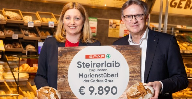 Ein Mann und eine Frau halten einen Spendenscheck hoch