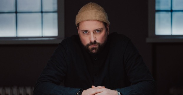 Schauspieler Felix von Jascheroff blickt als John Bachmann nachdenklich durch die Kulissen des GZSZ-Kiez