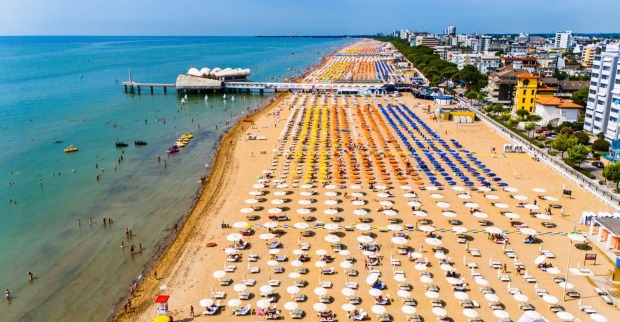 Strand Lignano Sabbiadoro mit Sonnenschirmen und Badegästen – tödlicher Badeunfall eines Österreichers vor der Küste