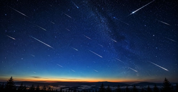 Sternschnuppen am klaren Nachthimmel über einer Landschaft während des Meteorstroms der Eta-Aquariiden im Mai