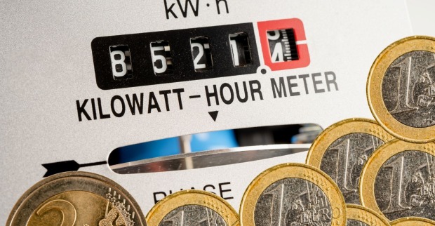 Stromzähler mit Kilowattstundenanzeige und Euro-Münzen als Symbol für Strompreise und Strompreisbremse in Österreich
