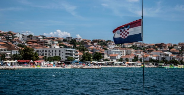 Blick auf einen Strand in Kroatien mit Ferienhäusern und Hotels.