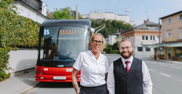 Busfahrerin und Busfahrer vor einem roten Obus | Credit: Salzburg Linien