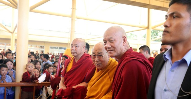 Der Dalai Lama lächelt in seiner traditionellen rot-gelben Robe