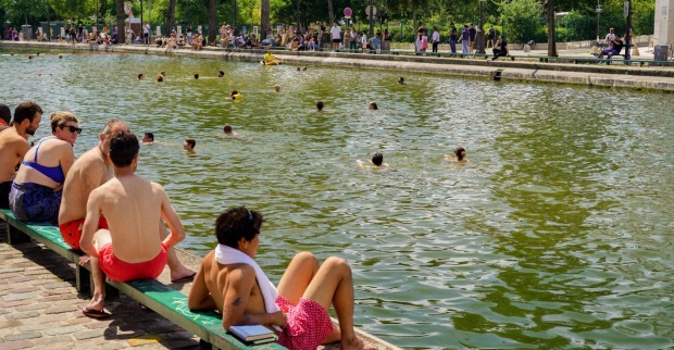 Menschen suchen bei extremer Hitze Abkühlung am Kanal in Paris – die Hitzewelle treibt viele in den öffentlichen Raum trotz Alkoholverbot
