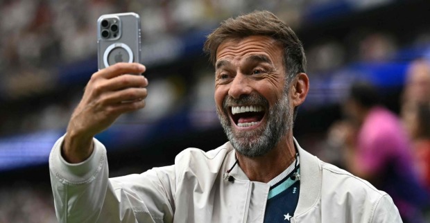 Jürgen Klopp lächelt und macht ein Selfie mit dem Smartphone im Stadion während der Fußball-WM 2026