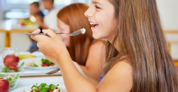 Jungen und Mädchen einer Schule beim gemeinsamen Mittagessen | Credit: Robert Kneschke/Shutterstock