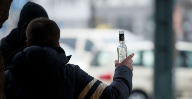Person hält eine Alkoholflasche an einem Bahnhof – geplantes Alkoholverbot auf Bahnhöfen soll für mehr Sicherheit und weniger Konflikte sorgen.
