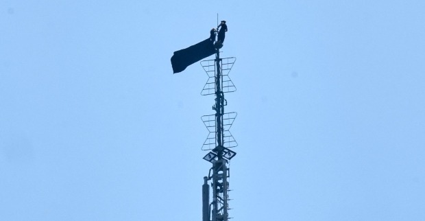 Empire State Building: Zwei Kletterer stehen auf der Antenne des berühmten Wolkenkratzers in New York und entrollen während ihrer spektakulären Verlobungsaktion ein Banner.