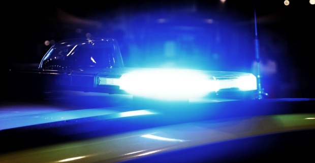 Ein Einsatzfahrzeug der Polizei steht mit Blaulicht vor einem Gebäude