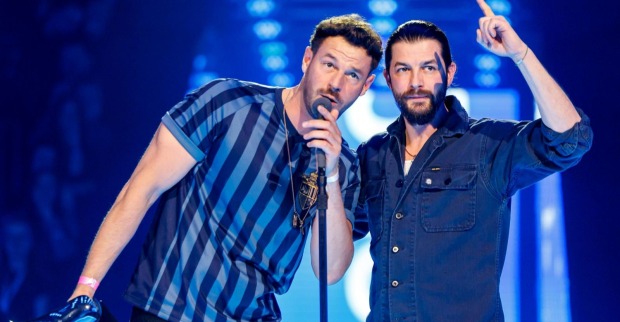 Pizzera &amp; Jaus bei einem Live-Konzert auf der Bühne. Paul Pizzera und Otto Jaus kündigen nach ihrer Tour eine Livepause an und wollen 2027 mit neuer Musik zurückkehren.