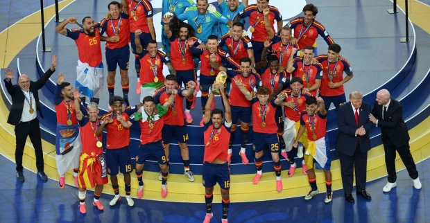 Spanien feiert den WM-Titel 2026 nach dem Finalsieg gegen Argentinien. Kapitän Rodri stemmt den WM-Pokal in die Höhe, während Donald Trump und FIFA-Präsident Gianni Infantino am Rand der Siegerbühne stehen.