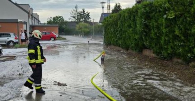 Feuerwehr bei Einsatz auf überfluteter Straße nach Starkregen in Wiener Neustadt Niederösterreich Wasser steht auf Fahrbahn