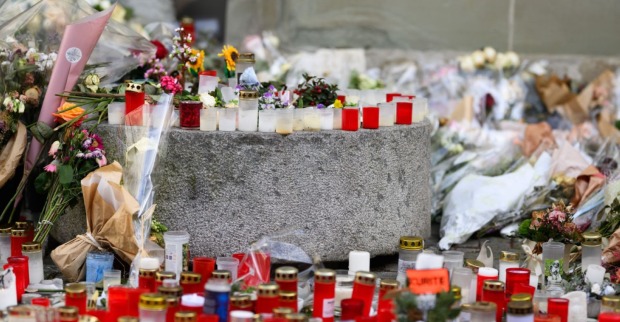 Gedenkstätte mit Kerzen und Blumen nach der Brandkatastrophe in Crans-Montana in der Schweiz.