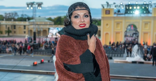 Anna Netrebko bei einem öffentlichen Auftritt vor einer beleuchteten Veranstaltungs-Kulisse./ Netrebko polarisiert auf Instagram
