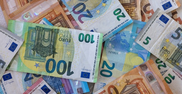 Farbiger Hintergrund mit Geld, Euro verschiedener Werte, als Symbolbild für die neuen Regeln mit dem Bargeld ab 2027.