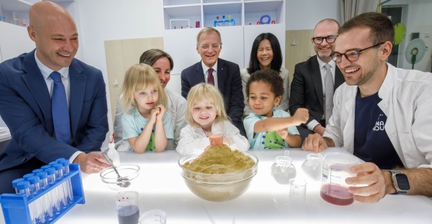 Martin Hajart, Obmann des DynaSprouts-Betreibers Familienbund Oberösterreich, Pädagogin Jasmin Öhner, DynaSprouts-Gesamtleitung, Thomas Stelzer, Landeshauptmann von Oberösterreich, Dynatrace-Mitgründerin Sok-Kheng Taing, der Linzer Bürgermeister Dietmar Prammer und Moritz König, STEAM-Koordinator von DynaSprouts, bei einem Experiment im DynaSprouts-Labor mit Kindern, die den Kindergarten und die Krabbelstube besuchen.