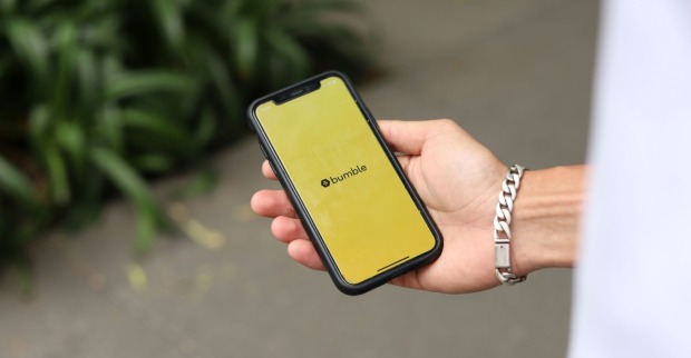 Bumble-App auf einem Smartphone in der Hand – die Dating-App ändert ihre Regeln für die erste Nachricht.