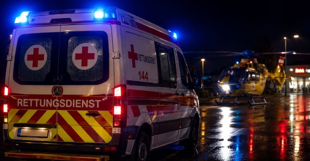 Rettungswagen mit Blaulicht bei Nacht nach einem schweren Car-Surfing-Unfall in der Steiermark. KI-Themenbild