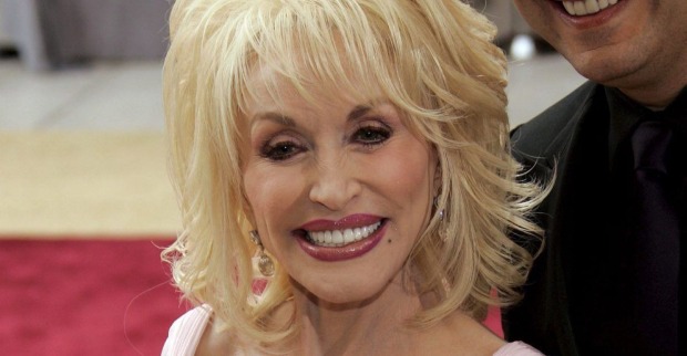 Dolly Parton lächelt bei einem öffentlichen Auftritt in die Kamera mit Ehemann Carl Dean