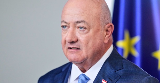 Bundeskanzler Christian Stocker bei einer Pressekonferenz vor einer EU-Flagge.