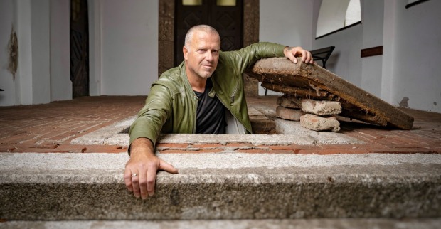 Bernhard Aichner klettert aus einem Schacht.