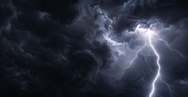 Dunkle Gewitterwolken und ein Blitz am Himmel