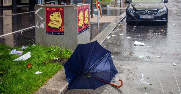Unwetterwarnung Wien: Umgestürzter Regenschirm auf nasser Straße bei starkem Regen und Sturm in Wien.