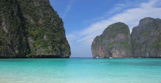 Türkisblaues Meer vor steilen Kalksteinfelsen in Thailand – traumhafte Küstenlandschaft in der Andamanensee, wo auch Würfelquallen (Seewespen) vorkommen können.